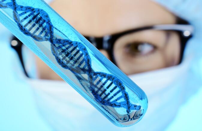 Forscherin hält Reagenzglas mit DNA-Doppelhelix