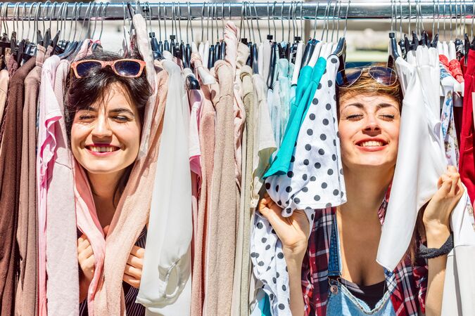 2 Frauen zeigen Freude mit gebrauchter Kleidung